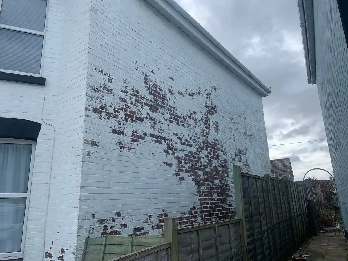 Peeling paint on a brick wall before redecoration in Axminster